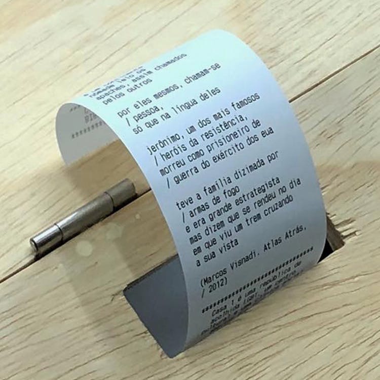 A picture of a thermal printer paper being spit out of a wooden box
